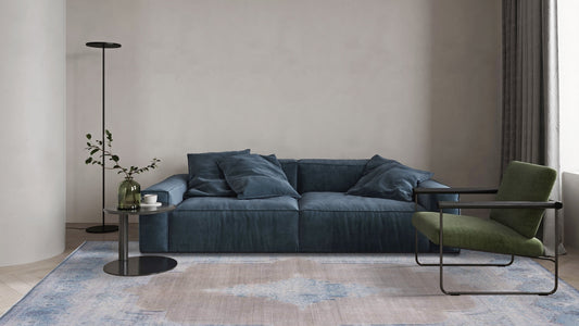 Vintage distressed area rug in modern living room with blue sofa